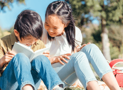 2人の子どもが一緒に本を読んでいる様子を撮影した画像